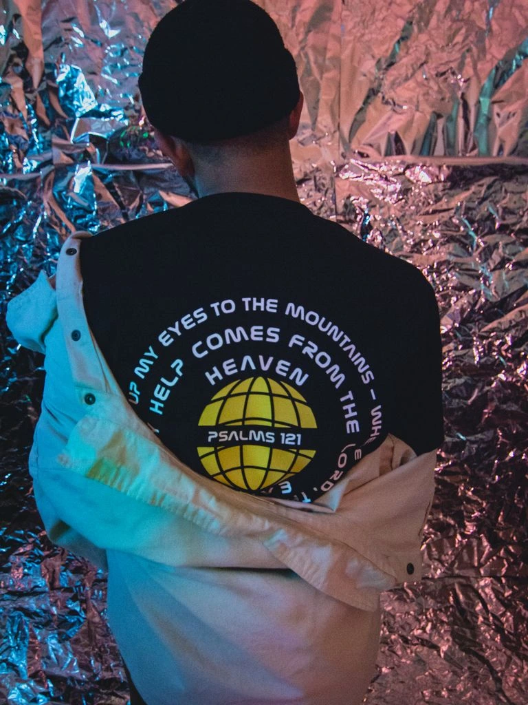 Same scripture tee worn by a woman reading on a sofa